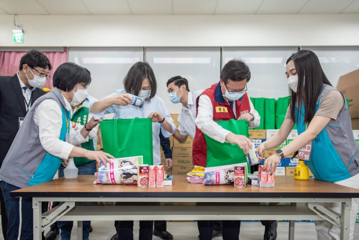 President Tsai Ing-wen (center left) and Taoyuan Mayor Cheng Wen-tsan (center right) pack supplies for local residents, who are infected with COVID-19 and in home quarantine Friday. Photo courtesy of Taoyuan City government