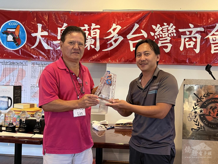 九九高爾夫球俱樂部會長Fred Lin(左)頒贈紀念獎牌，由大奧蘭多臺商會前會長林哲光(右)代表接受