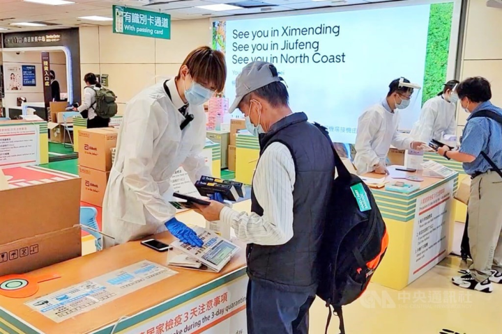 Airport workers offer free rapid test kits to arriving passengers at Taiwan Taoyuan International Airport on Thursday. CNA photo Sept. 29, 2022