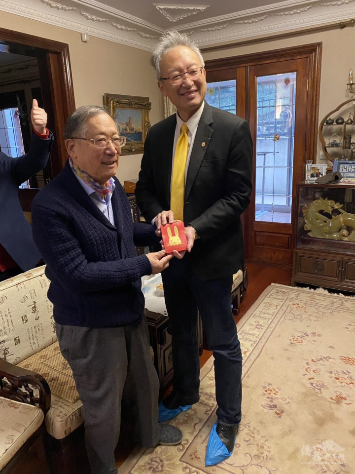 吳志中（右）代表總統蔡英文致送總統府1元福袋及春聯予法國中華會館，由丁偉星（左）代表收受。