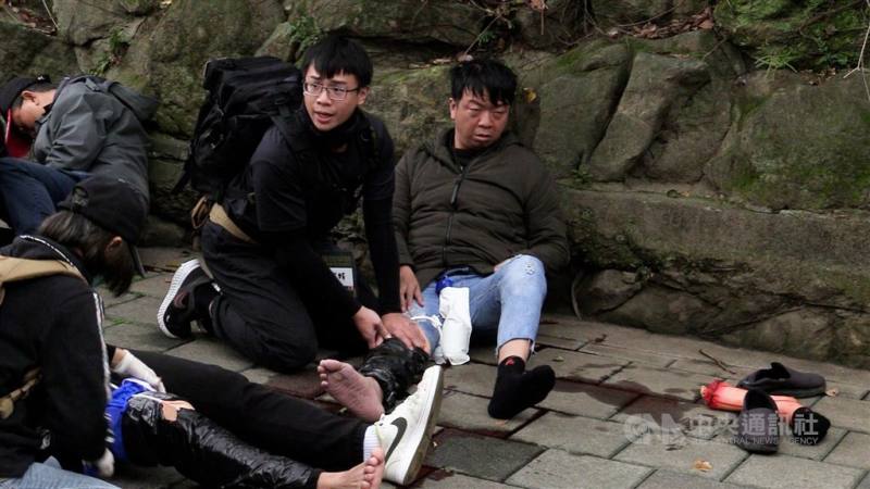 A drill participant provides first aid to another next to a fake severed lake to stimulate a real life wartime response situation in Taipei Saturday. CNA photo Jan. 27, 2024