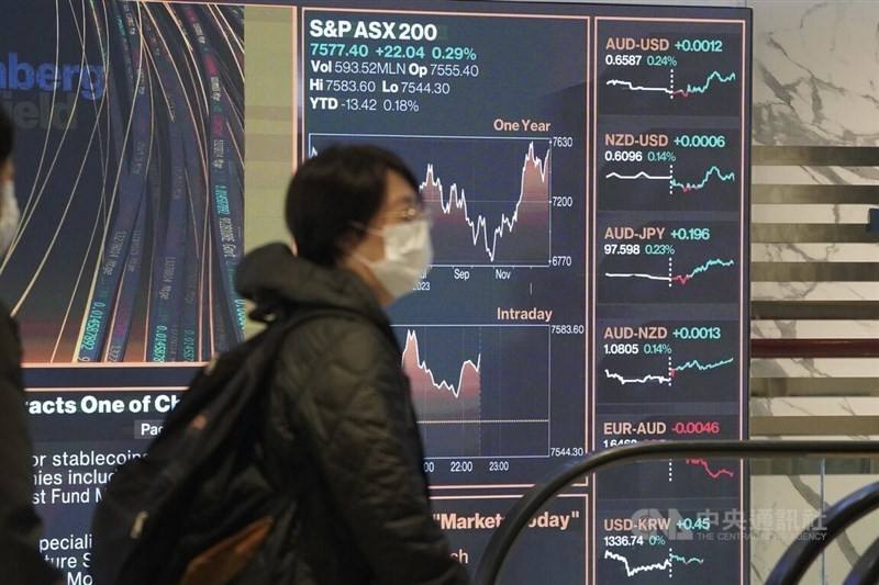 A woman walks past the Taiwan Stock Exchange's display of global financial markets in Taipei on Monday. CNA photo Jan. 29, 2024