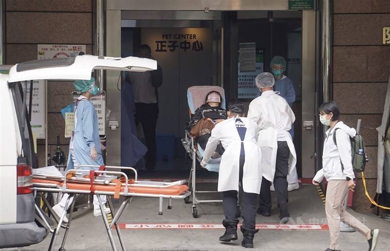 Medical professionals escort a man into a hospital