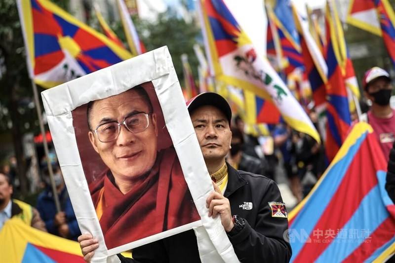 A man holds up a photo of Dalai Lama, Tibet's spiritual leader, at a Tibet uprising commemoration in Taipei Sunday. CNA photo March 10, 2024