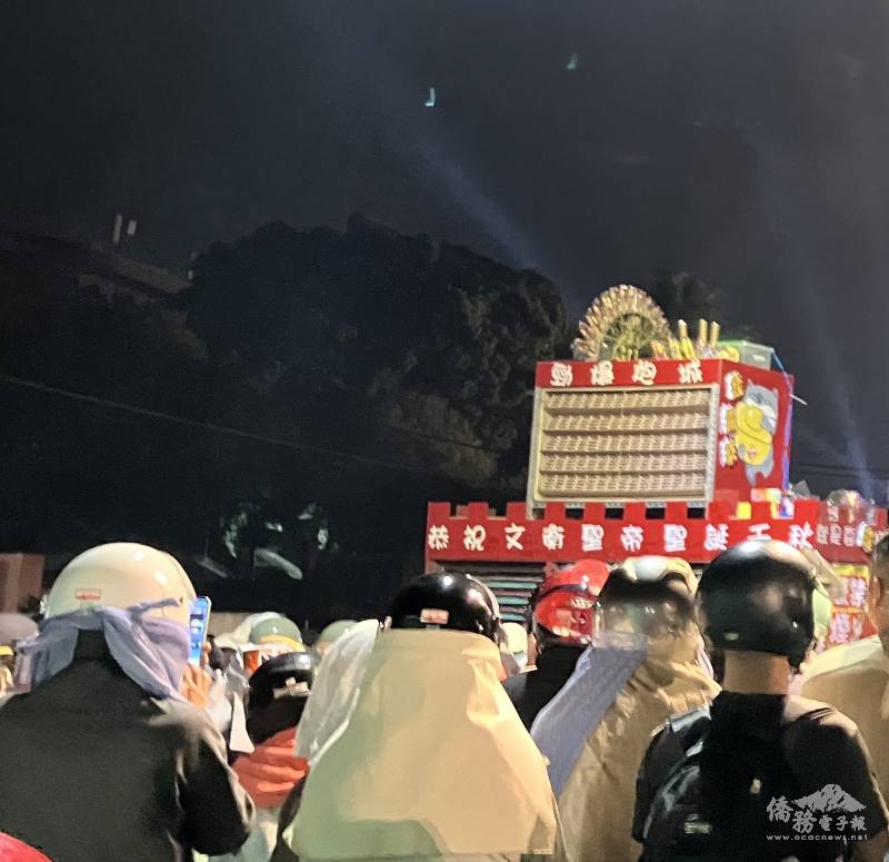 A decorated beehive structure being carted through Yanshui, followed by crowds of people wearing protective clothing.