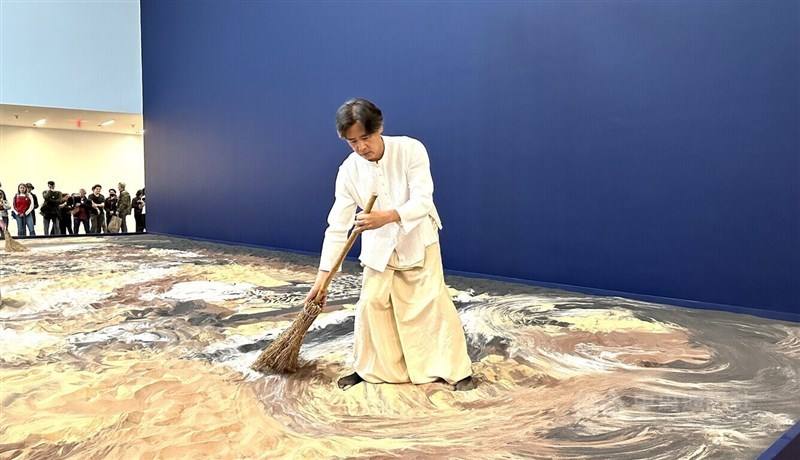 Taiwan-born artist Lee Ming-wei sweeps sands during a presentation at the de Young Museum in San Francisco on March 23, 2024. Photo: CNA