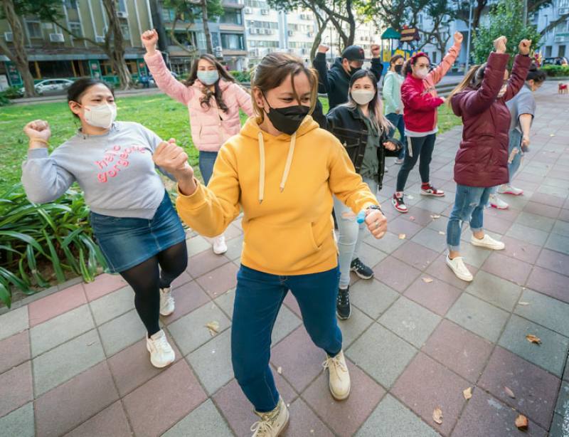 Filipinos use their days off to practice dancing in the park.