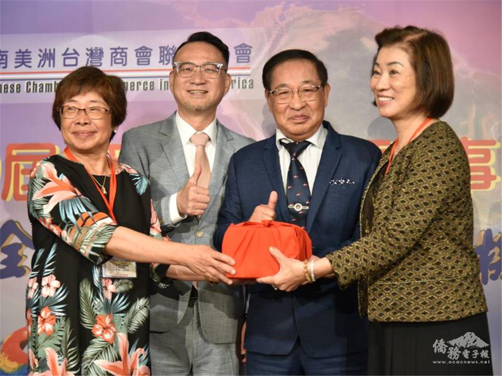 由世界臺灣商會聯合總會總會長李天柒(右2)監交，中南美洲臺商會聯合總會第29屆總會長陳淑芬(左1)交接印信予第30屆總會長林幸昭(右1)，僑務委員會副委員長阮昭雄(左2)出席見證。