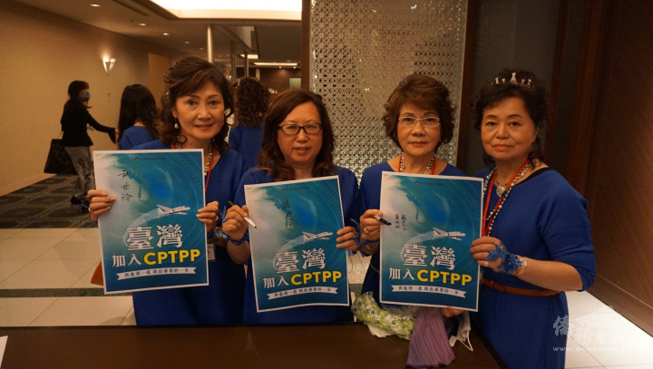 世華日本分會會長錢妙玲(圖左二)與其幹部持支持臺灣加入CPTPP海報，呼籲大家支持臺灣