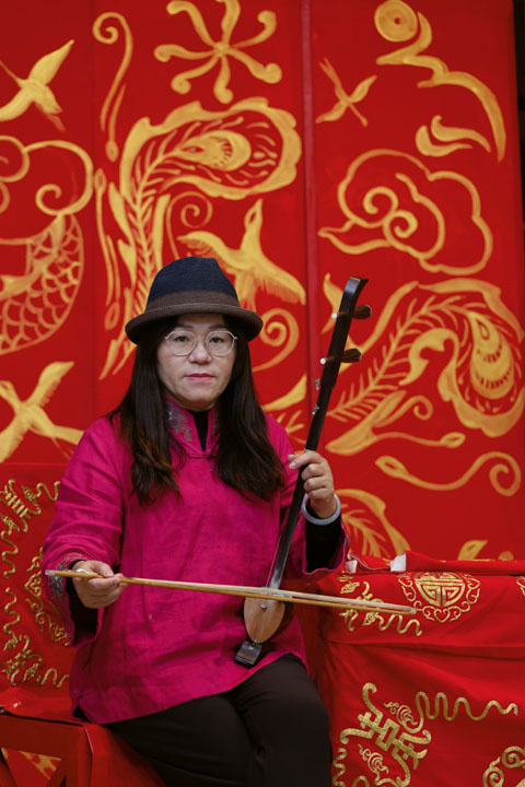 Chen Yu-hwan, director of the Hanyang Beiguan Troupe, also plays first fiddle in musical performances. She is shown here with a kezaixian (a two-stringed spike fiddle with a sound box made from a coconut shell).
