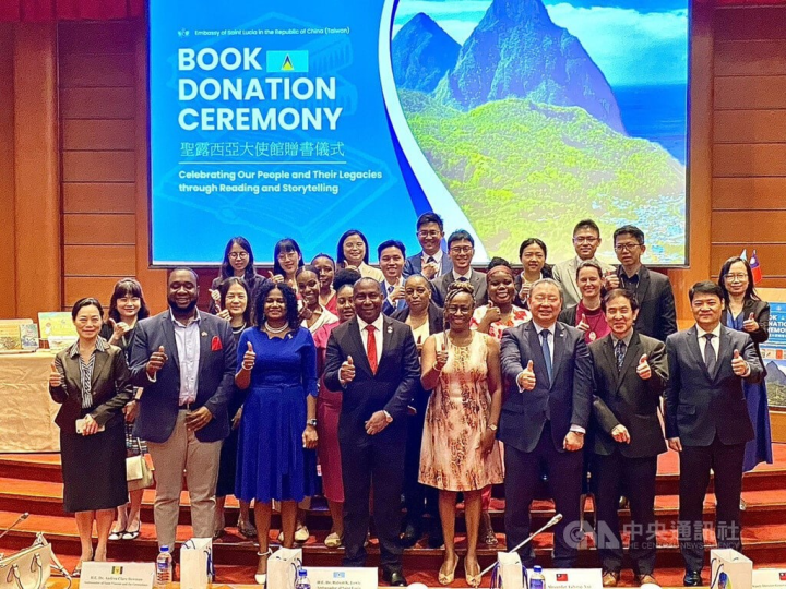Saint Lucia Ambassador to Taiwan Robert Kennedy Lewis (front row, fourth from left) and Deputy Minister of Foreign Affairs Yui Tar-ray (front row, third from right) at the book donation ceremony Tuesday. 