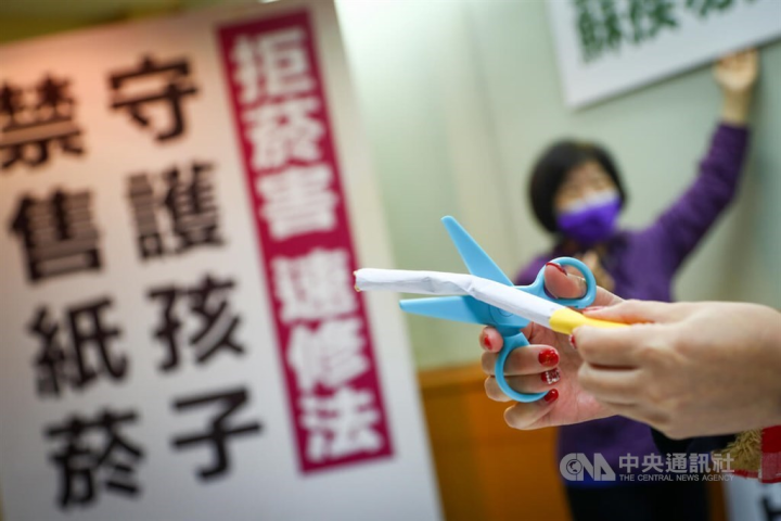 A prop cigarette is used during a press conference held by parents and civic groups to call for amending the Tobacco Hazards Prevention Act in Taipei on Jan. 5, 2022