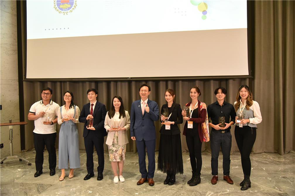 2022年10月25日僑委會委員長童振源於「全球僑界青年高峰會」閉幕典禮中頒發首屆親善大使獎牌，並與其中返臺的8位得主合影。