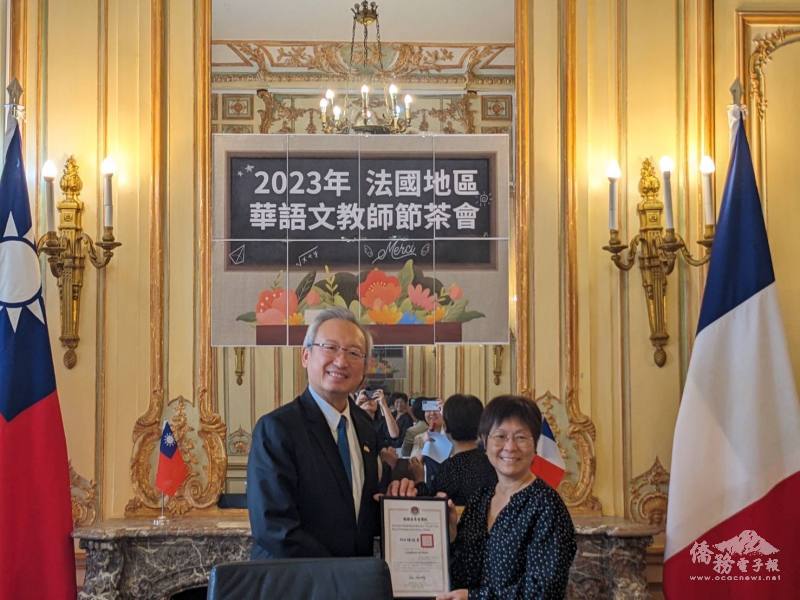 吳志中（左）代表僑委會委員長徐佳青頒發10年屆海外僑民教師獎勵獎狀予老師薛羽娥（右）。