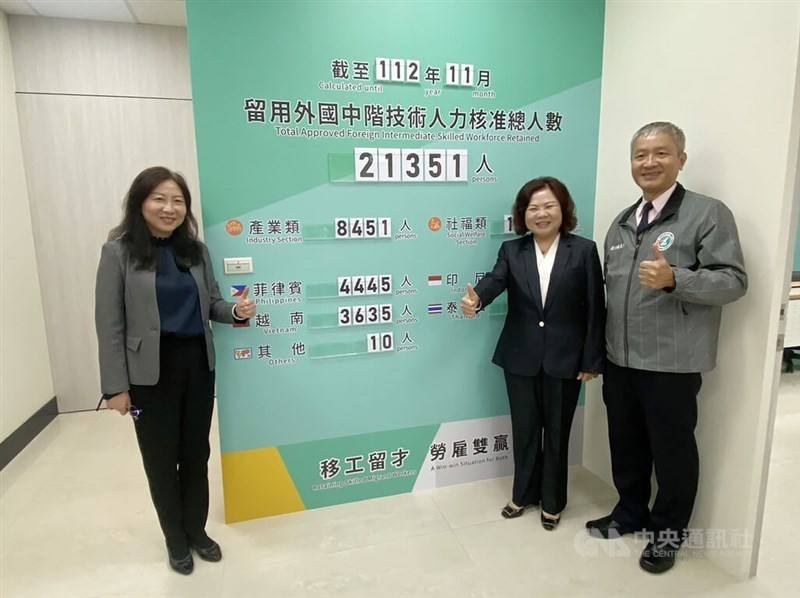Labor Minister Hsu Ming-chun (second right) stands next to a board showing the number of skilled workers who obtained approval in the retention program in Hsinchu County on Dec. 6, 2023. CNA photo