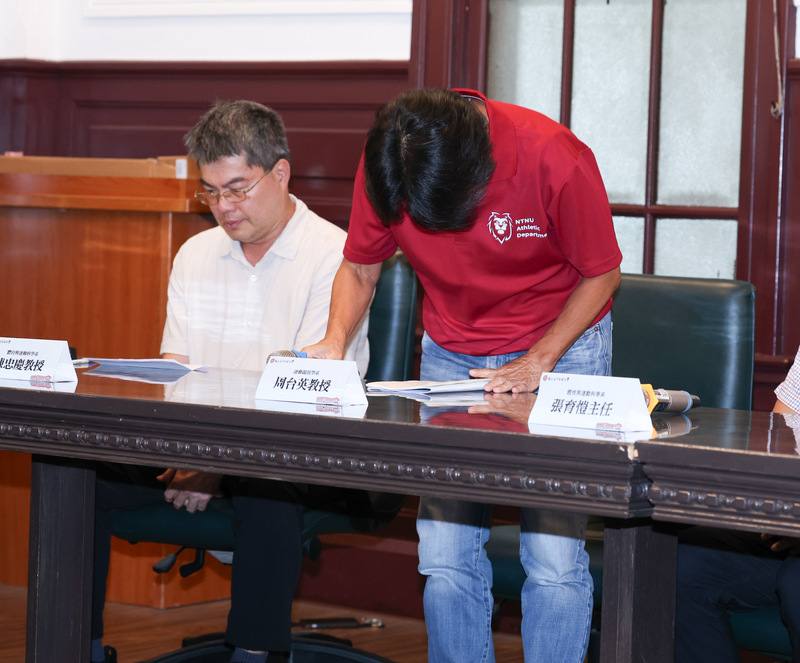 Chou Tai-ying (right), the former coach of the National Taiwan Normal University women's soccer team, bows and apologizes in Taipei on Saturday.