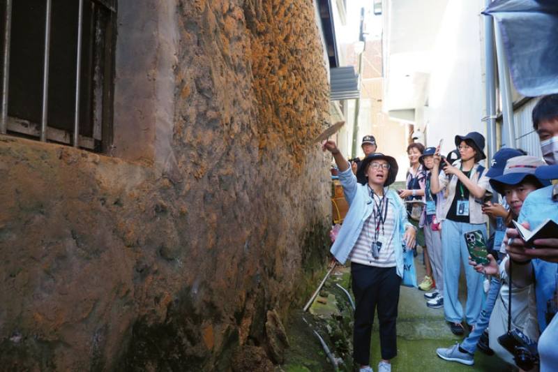 Wu Hanen’s Dawn Culture Studio offers guided tours. This photo shows her introducing a typical local house built from sandstone.