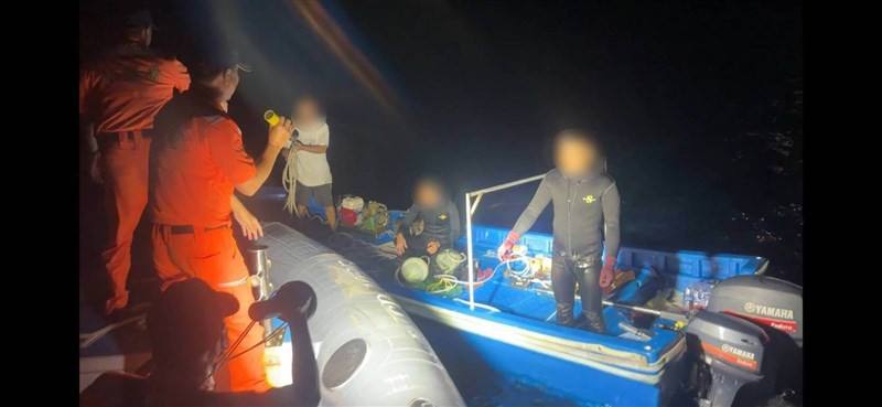 A Taiwan Coast Guard Administration officer spots a Chinese fishing raft in waters northeast of Dongsha on Saturday. Photo courtesy of Coast Guard Administration