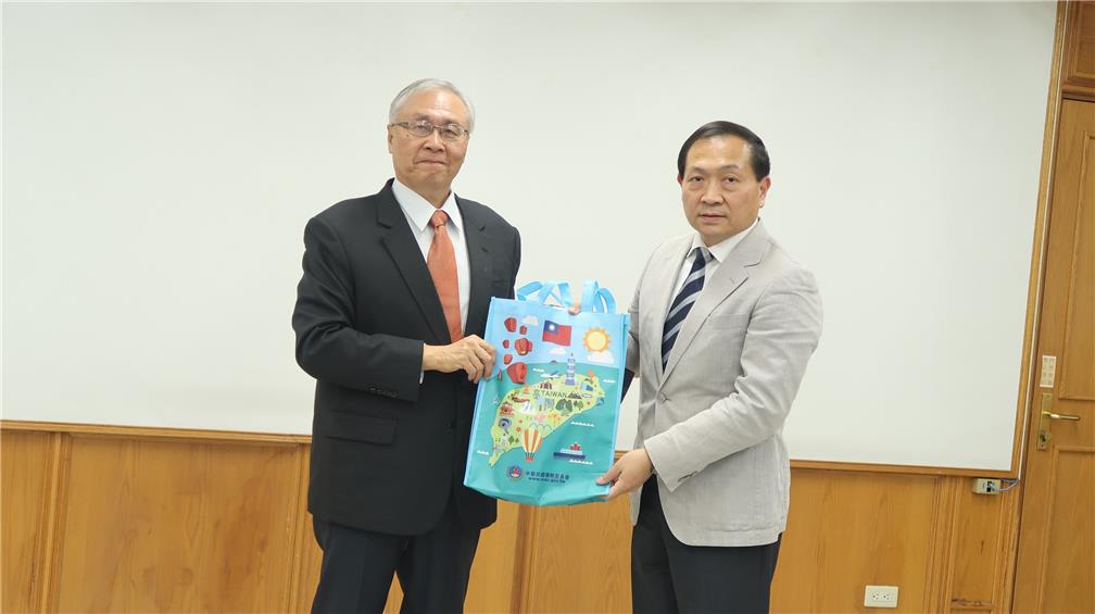 Chang Liang-Min, OCAC Chief Secretary presents a souvenir to the president of Yokohama Overseas Chinese School (right).