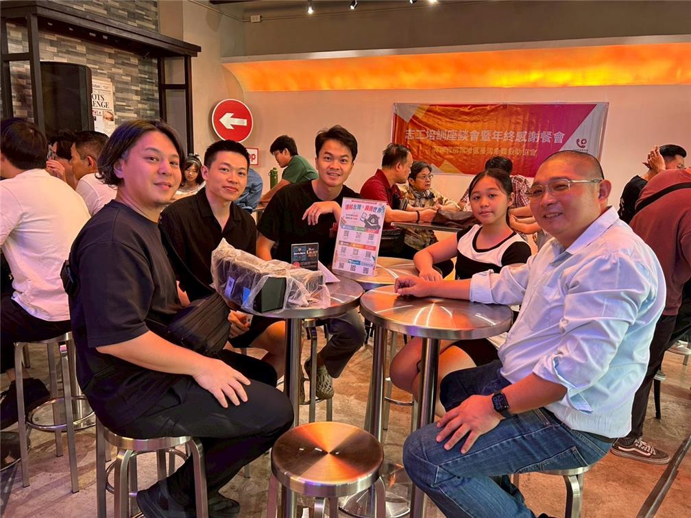 會長邱裕文(右)主持志工培訓座談會，另向志工介紹並推廣 i僑卡。